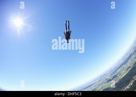 Female skydiver free falling head first above Leutkirch, Bavaria, Germany