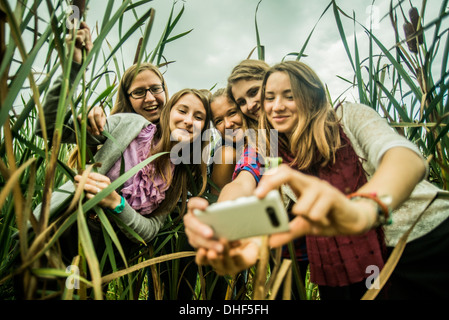 Five young women taking self portrait in marshes Stock Photo