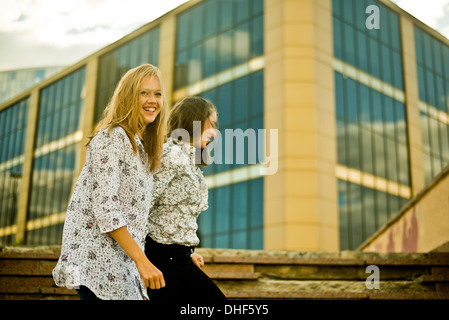 Two young women walking in front of office bulding Stock Photo