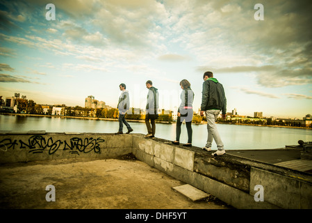 Four friends walking along concrete wall, Russia