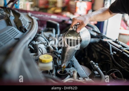 Mechanic pouring liquid into car Stock Photo