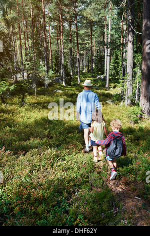 Father and daughters walking through forest Stock Photo