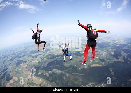 Three skydivers free falling above Leutkirch, Bavaria, Germany Stock Photo