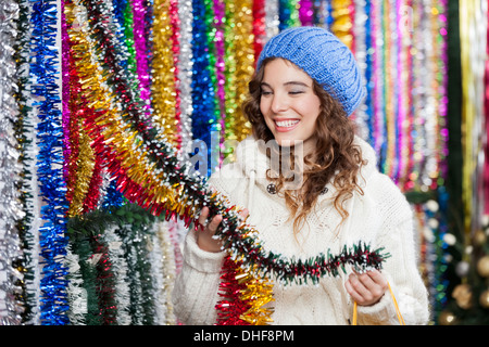 Young Woman Choosing Tinsels At Store Stock Photo