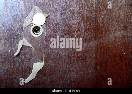 Peephole spyhole lens on new wooden door Stock Photo
