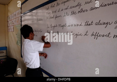 A schoolgirl writing on a board during English lecture in a high school in Carti Sugtupu island village administered by Guna natives known as Kuna in the 'Comarca' (region) of the Guna Yala located in the archipelago of San Blas Blas islands in the Northeast of Panama facing the Caribbean Sea. Stock Photo