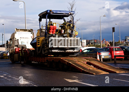 A road resurfacing vehicle is being driven up onto a long transporter at The Waterfront Development area in Dundee, UK Stock Photo