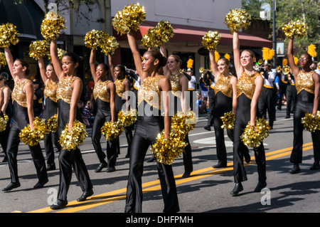 Buchholz High School marching band majorettes, yellow and black with gold pom poms, University of Florida Homecoming Parade 2013 Stock Photo