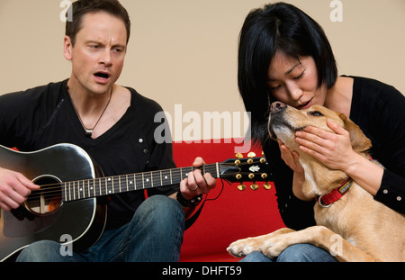 man and woman singing to dog Stock Photo