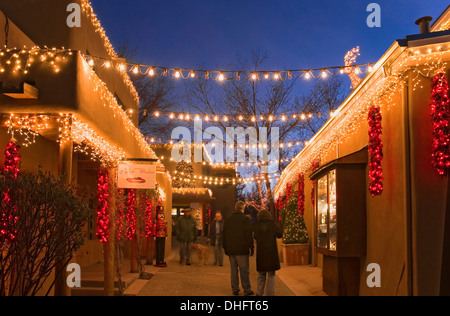 Strollers and Christmas lights during 'Farolito Walk' (Christmas Eve), Gypsy Alley, off Canyon Road, Santa Fe, New Mexico USA Stock Photo
