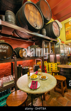 Old bar with wooden barrels and tapas served on a table, Barri Gotic, Barcelona, Catalonia, Spain Stock Photo