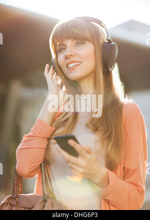 Young beautiful girl listening to MP3 player on the street Stock Photo