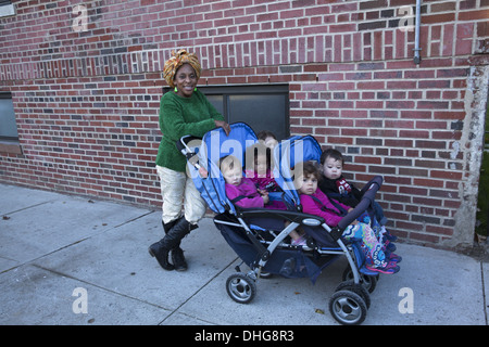 Nursery school teacher with kids on a neighborhood outing in the multicultural Kensington neighborhood of Brooklyn, NY. Stock Photo
