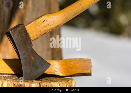 Ax stuck in block of wood winter Stock Photo