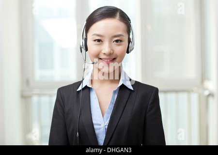 Young woman using laptop and wearing headset Stock Photo