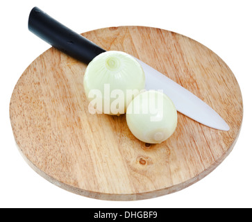 two peeled onions bulbs with ceramic knife on wooden cutting board isolated on white background Stock Photo