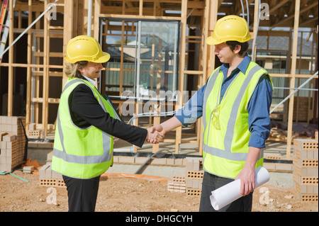 civil engineer and worker shaking hands at the construction site Stock Photo