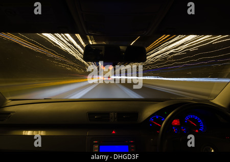 view through the windscreen of a moving car with motion blur and different sections on the motorway with road works cars lorries Stock Photo