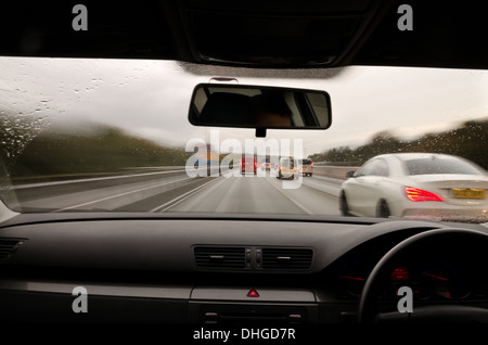 view through the windscreen of a moving car with motion blur and different sections on the motorway with road works cars lorries Stock Photo