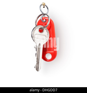 House key and red key fob hanging on nail against white background, clipping path included Stock Photo