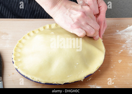 making a plate pie, crimping the edge of the pastry Stock Photo