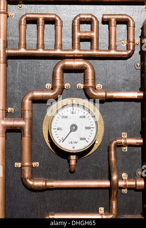 The word Mad written in Copper Piping and Temperature Gage on Black Background Stock Photo