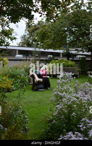 Two friends having afternoon tea in a garden Stock Photo