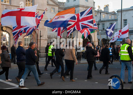 London, UK. 10 November 2013. An Apartheid era South African flag flies amongst British, Scottish and English flags as members of the right wing National Front march from the Cenotaph after the main Remembrance Day ceremonies, where they laid a wreath. Credit:  Paul Davey/Alamy Live News Stock Photo