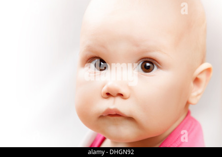 Little brown eyed Caucasian baby girl closeup studio portrait on white background Stock Photo