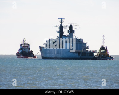 The last of the Royal Navies Type 22 Frigates HMS Cumberland leaves Portsmouth Harbour under tow, heading for a scrapyard Stock Photo