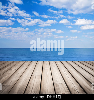 Empty wooden pier with sea and cloudy sky on background Stock Photo