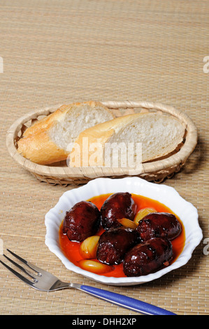 Mini chorizo sausages and garlic in olive oil tapas, Costa del Sol, Malaga Province, Andalusia, Spain, Western Europe. Stock Photo