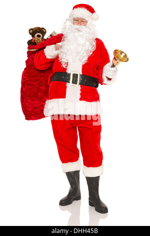Santa Claus or Father Christmas carrying a sack full of gift wrapped presents and toys, isolated on a white background. Stock Photo