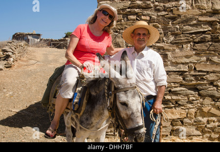 Greece Paros Cyclades old local man with donkey near Lefkes in mountains at his farm home with woman tourist on donkey 8 4 Stock Photo