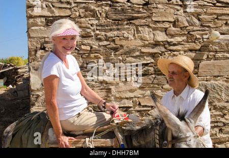 Greece Paros Cyclades old local man with donkey near Lefkes in mountains at his farm home with woman tourist on donkey 8 1 Stock Photo