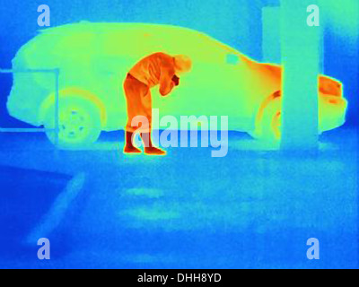 Thermal photograph of a burglar breaking into a car Stock Photo