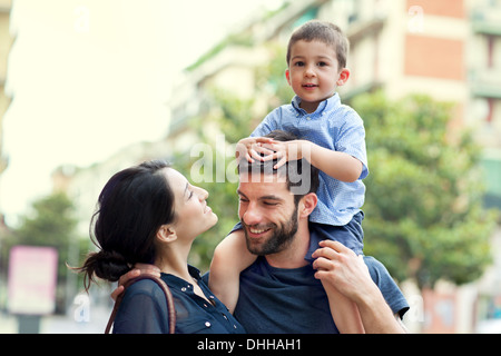 Father carrying son on shoulders with woman Stock Photo
