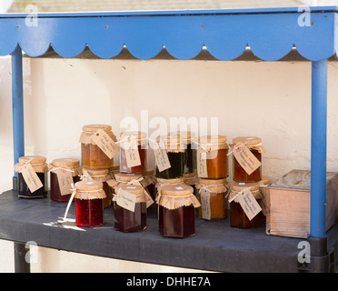 Home made jams preserves and jars for sale in pots with labels and honesty box for payment Stock Photo