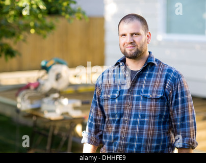 Confident Manual Worker Standing At Construction Site Stock Photo