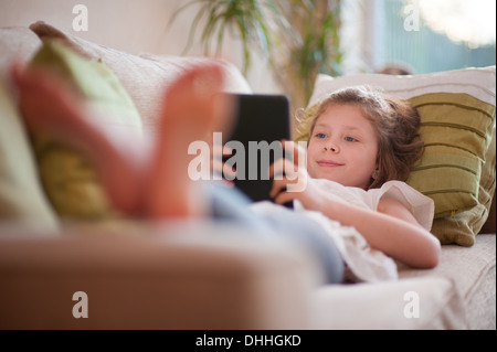 girl on a sofa using a tablet computer Stock Photo