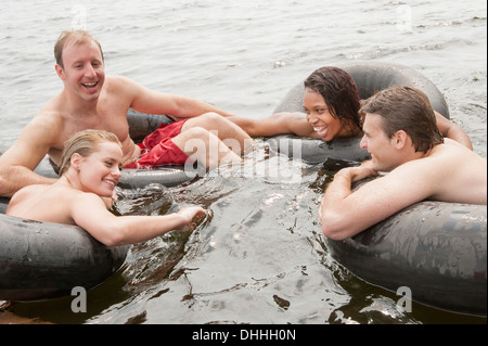 Friends floating in inflatable rings Stock Photo