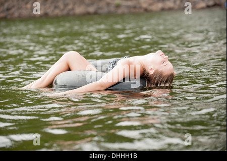 Young woman floating in inflatable ring Stock Photo