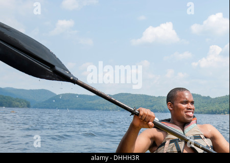 Young man wearing life vest holding oar Stock Photo