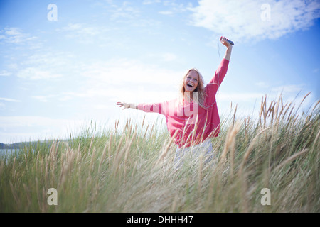 Portrait of woman dancing in marram grass, Wales, UK