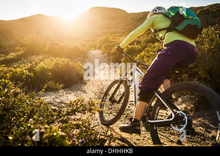 Young woman mountain biking on dirt track, Monterey, California, USA Stock Photo