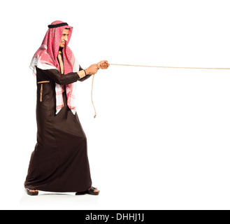 Young Arab pulling a rope isolated on white background Stock Photo