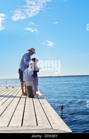 Grandfather and grandsons fishing, Utvalnas, Sweden Stock Photo