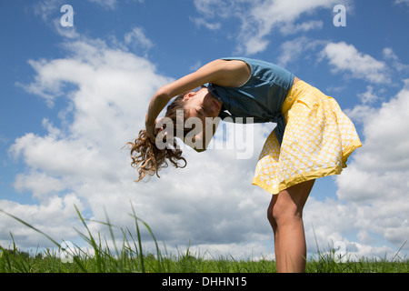 Teenage girl bending forward with hands in hair Stock Photo