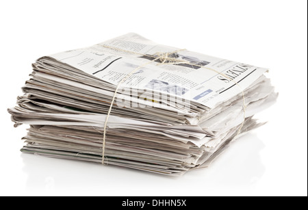 Tied up stack of old newspapers collected for recycling on white background Stock Photo