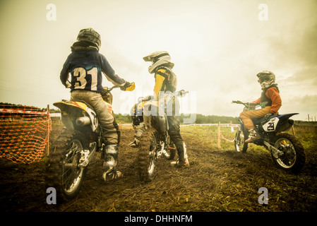 Young man and boys on motorcycles at motocross Stock Photo